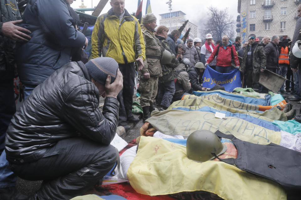 FILE - In this file photo taken on Feb. 20, 2014, activists pay respects to protesters killed during clashes with riot police in Kyiv's Independence Square. On Nov. 21, 2023, Ukraine marks the 10th anniversary of the uprising that eventually led to the ouster of the country’s Moscow-friendly president. (AP Photo/Efrem Lukatsky, file)