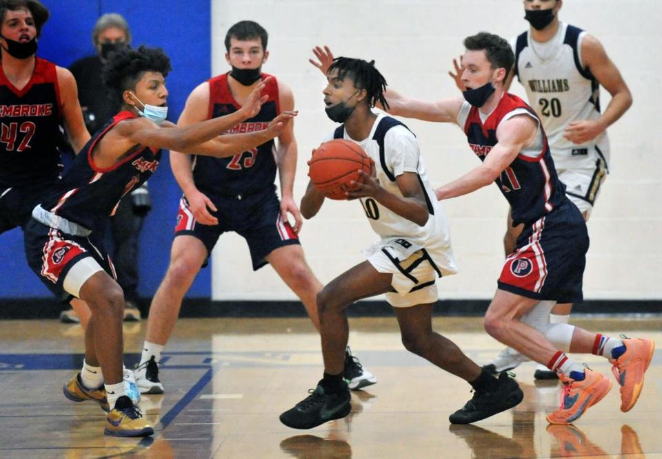 Archbishop Williams' Andre Espaillant, center, is surrounded by Pembroke defenders from left, Devanti Perry, Tom Considine and Connor Lockhart during the Titans Holiday Classic at Pembroke High School on Thursday, Dec. 30, 2021.