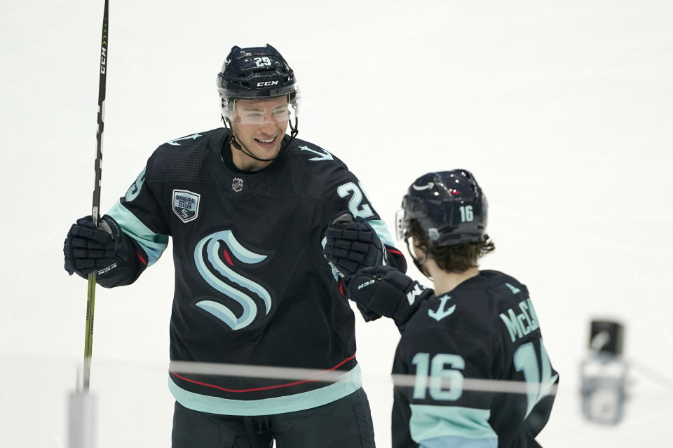 Seattle Kraken defenseman Vince Dunn, left, greets center Jared McCann after McCann scored a goal against the Carolina Hurricanes with an assist from Dunn during the second period of an NHL hockey game Wednesday, Nov. 24, 2021, in Seattle. (AP Photo/Ted S. Warren)