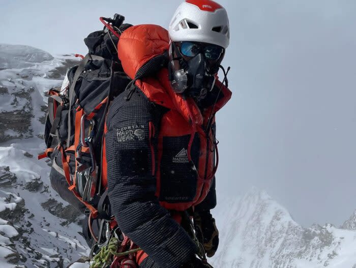 A climber in high altitude gear, O2, glasses and helmet, his face totaly covered. 