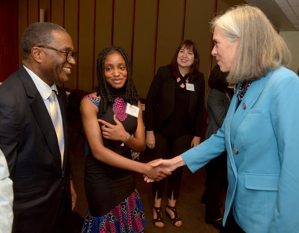 U.S. Rep. Katherine Clark, D-Mass., shakes hands with Melody Obi-Ngo, of Waltham, as her father, Franklin Ngo, looks on. Clark announced a $600,000 expansion of the MetroWest Scholars Early Start program, early college funding for Waltham students, at Framingham State University, May 3, 2022. Second from right is Colleen Coffey, executive director of the College Planning Collaborative.