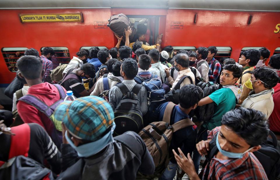 Migrant workers and their families board an overcrowded passenger train, after government imposed restrictions on public gatherings in attempts to prevent spread of coronavirus disease (COVID-19), in Mumbai, India, March 21, 2020. REUTERS/Prashant Waydande