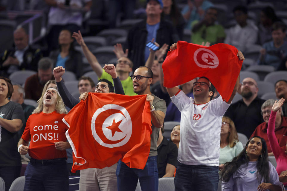 Fans holding Tunisian flags cheer for Ons Jabeur of Tunisia during the third set of her match against Jessica Pegula in round robin-play on day three of the WTA Finals tennis tournament in Fort Worth, Texas, Wednesday, Nov. 2, 2022. Jabeur won 1-6, 6-3, 6-3. (AP Photo/Tim Heitman)
