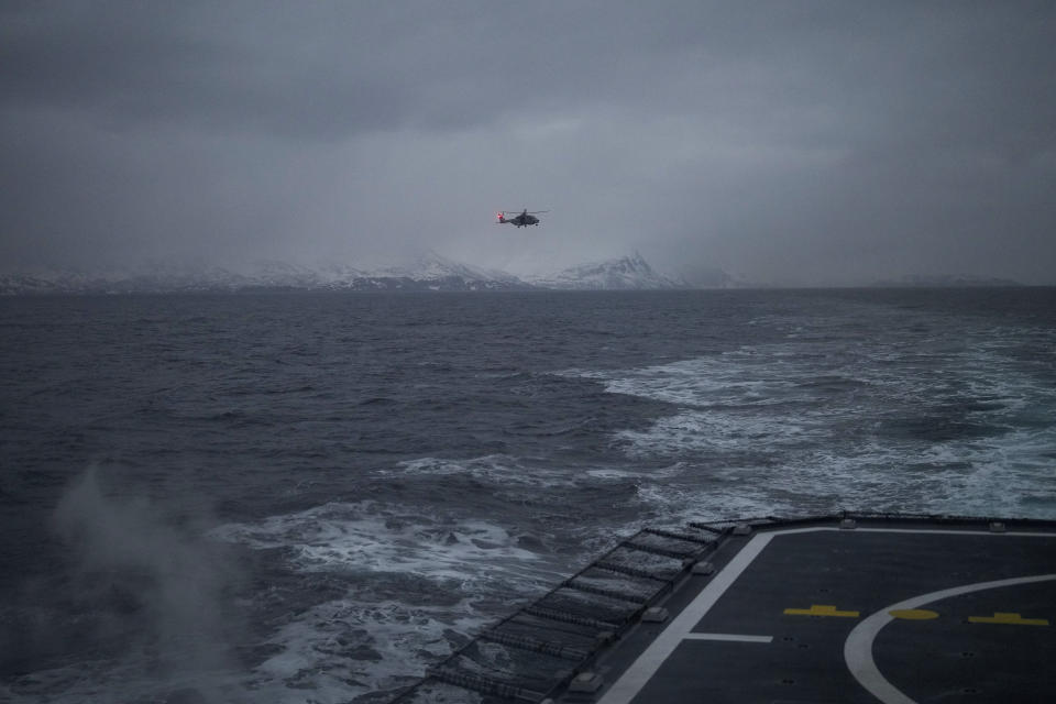 A helicopter approaching to land on the French navy frigate Normandie during a patrol in a Norwegian fjord, north of the Arctic circle, Thursday March 7, 2024. The French frigate is part of a NATO force conducting exercises in the seas, north of Norway, codenamed Steadfast Defender, which are the largest conducted by the 31 nation military alliance since the cold war. (AP Photo/Thibault Camus)