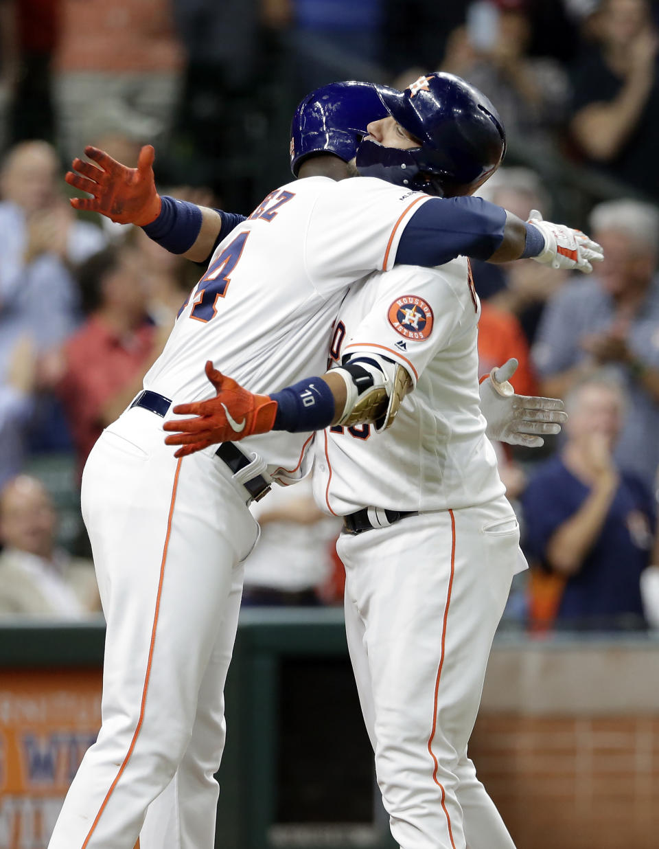 Houston Astros' Yordan Alvarez, left, and Yuli Gurriel, right, hug at home plate after they both scored on Gurriel's two-run home run during the fifth inning of a baseball game against the Texas Rangers Wednesday, Sept. 18, 2019, in Houston. (AP Photo/Michael Wyke)