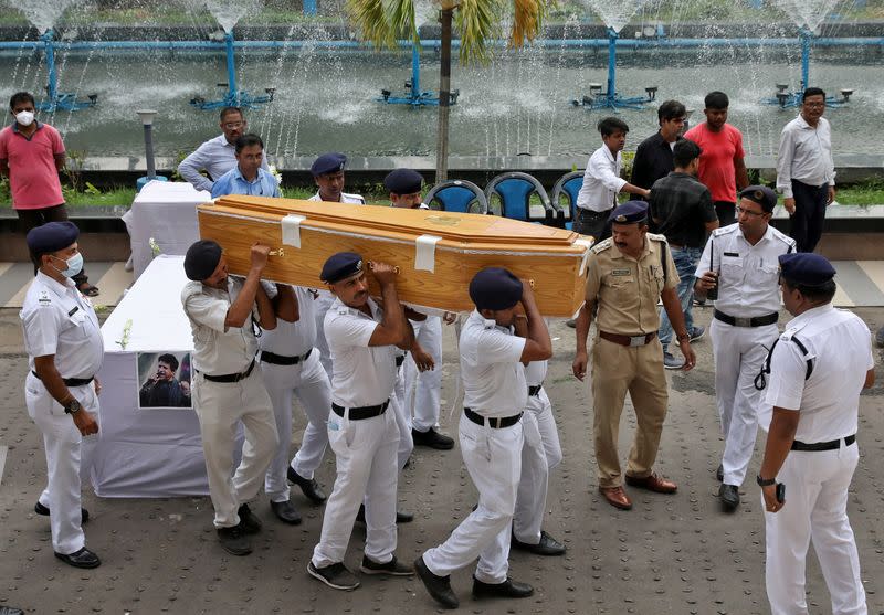 Police officers carry the coffin containing body of Indian singer KK after a gun salute in Kolkata