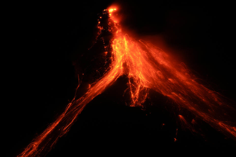 Lava flows down the slopes of Mayon volcano as seen from Daraga town, Albay province, northeastern Philippines, Tuesday, June 13, 2023. Truckloads of villagers on Tuesday fled from Philippine communities close to gently erupting Mayon volcano, traumatized by the sight of red-hot lava flowing down its crater and sporadic blasts of ash. (AP Photo/Aaron Favila)