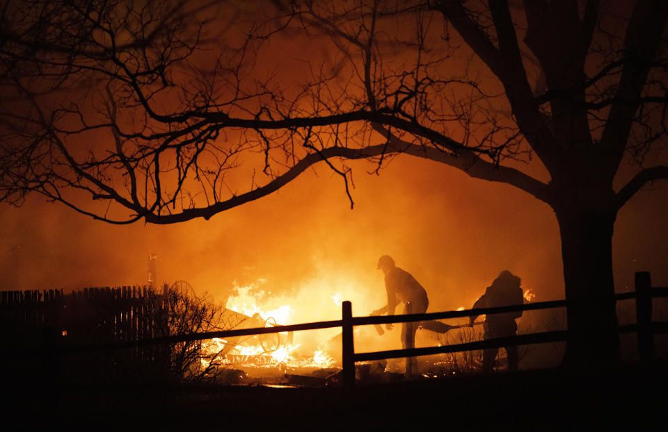 FILE - Residents fight the Marshall Fire in Louisville, Colo., Thursday, Dec. 30, 2021. A wildfire that destroyed nearly 1,100 homes and businesses in suburban Denver last winter caused more than $2 billion in total financial losses -- by far the costliest in Colorado history, the state insurance commissioner says. (Christian Murdock/The Gazette via AP, File)