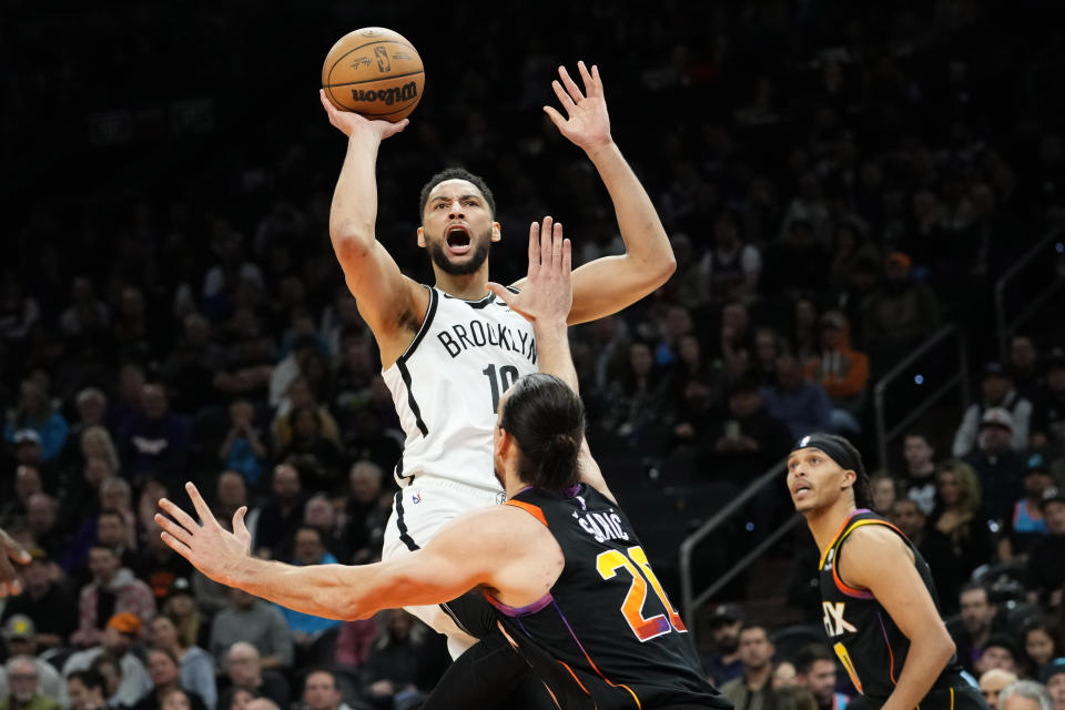 Brooklyn Nets guard Ben Simmons (10) shoots over Phoenix Suns forward Dario Saric (20) during the first half of an NBA basketball game, Thursday, Jan. 19, 2023, in Phoenix. (AP Photo/Matt York)