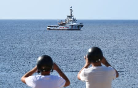 Tourists take pictures of the Spanish migrant rescue ship Open Arms close to the Italian shore in Lampedusa