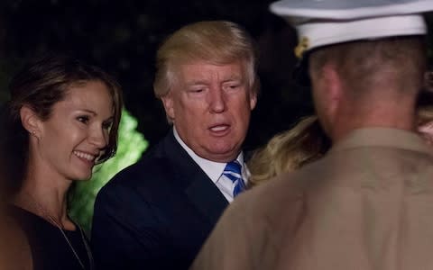 Donald Trump stops to talk with a Marine Corps officer and his family on his return to the White House on Sunday - Credit: AP