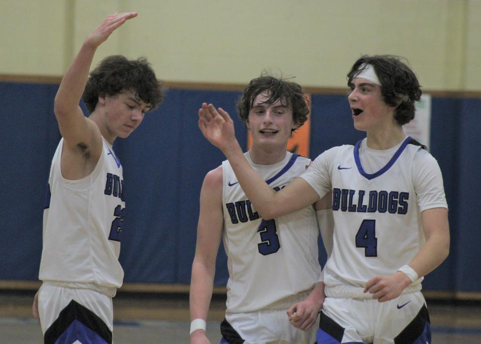 Inland Lakes' Kaden Hansel (4), Connor Knight (3) and Cash DePauw (23) celebrate immediately following the Bulldogs' Ski Valley title-clinching victory over Gaylord St. Mary on Tuesday.