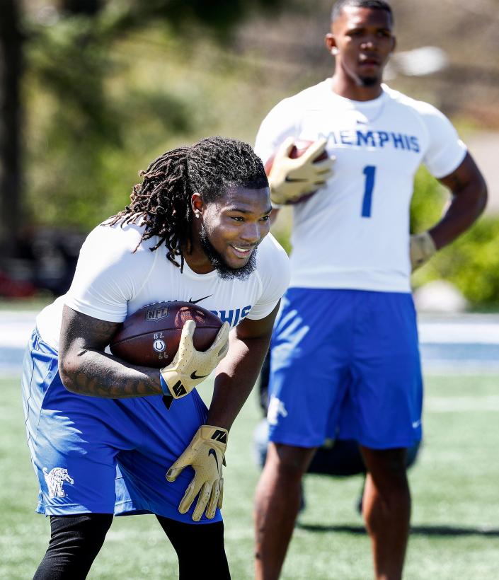 Running back Darrell Henderson runs through agility drills with former teammate Tony Pollard (back) during Memphis' football Pro Day on South Campus, Wednesday, March 27, 2019.