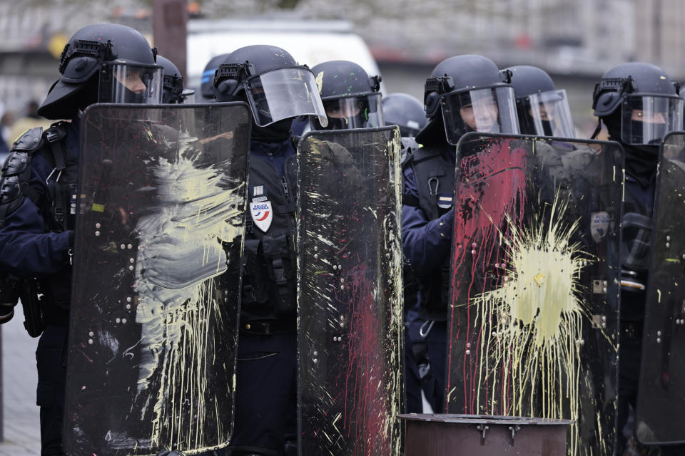 Police officers stands behind their shields covered in paint thrown by protesters during a demonstration in Nantes, western France, Saturday, March 11, 2023. Opponents of President Emmanuel Macron's hotly contested plan to raise the retirement age from 62 to 64 were taking to the streets of France on Saturday for the second time this week in what union's hope will be a new show of force meant to push the government to back down. (AP Photo/Jeremias Gonzalez)