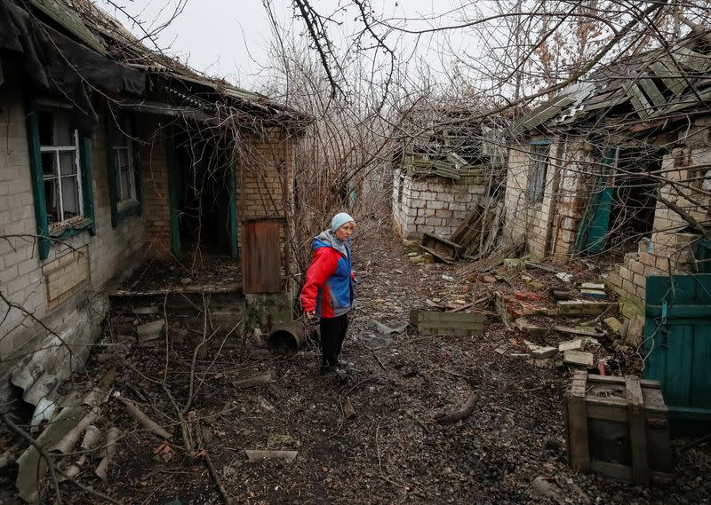 Local resident is seen near houses damaged by shelling in the village of Zaitseve