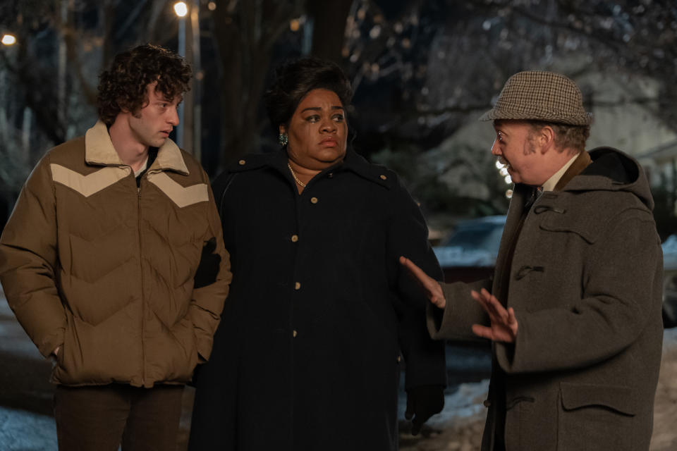 three people wearing jackets talking outside