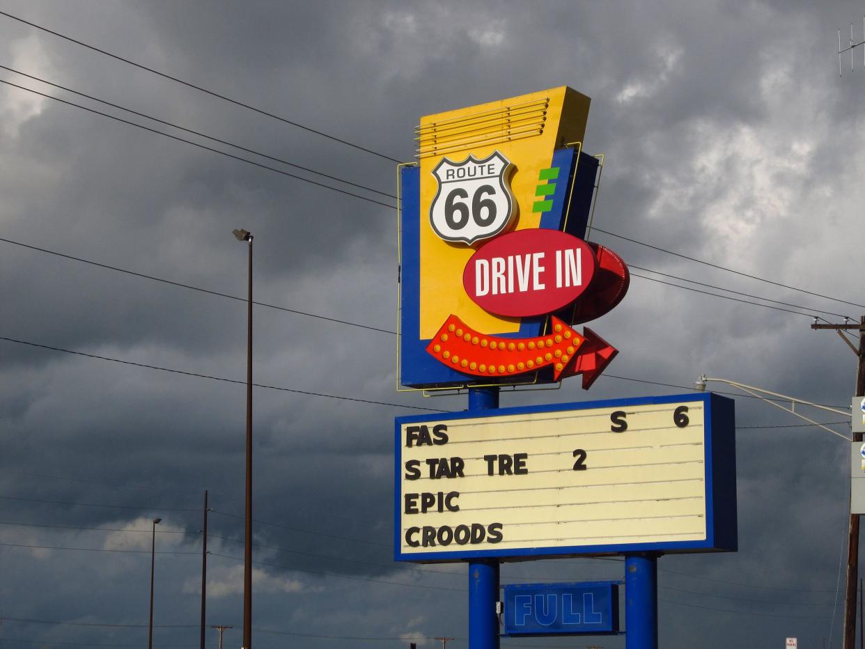 Sign for Route 66 Drive-In in Springfield, IL with cloudy dramatic sky in the background.