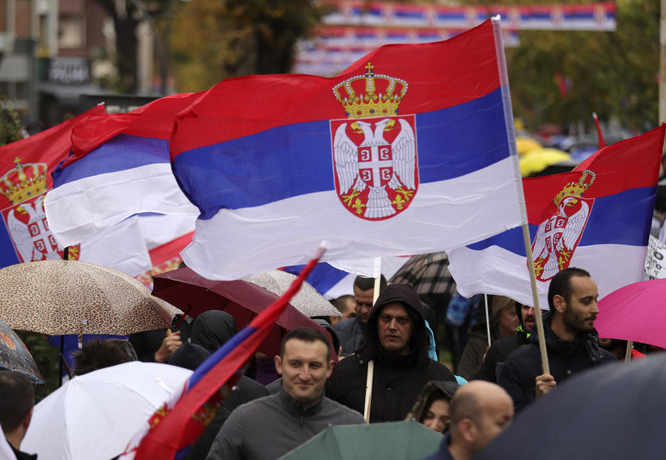 Kosovo Serbs wave Serbian flags during a protest in Mitrovica, Kosovo, Sunday, Nov. 6, 2022. Several thousand ethnic Serbs on Sunday rallied in Kosovo after a dispute over vehicle license plates triggered a Serb walkout from their jobs in Kosovo's institutions and heightened ongoing tensions stemming from a 1990s' conflict. (AP Photo/Bojan Slavkovic)