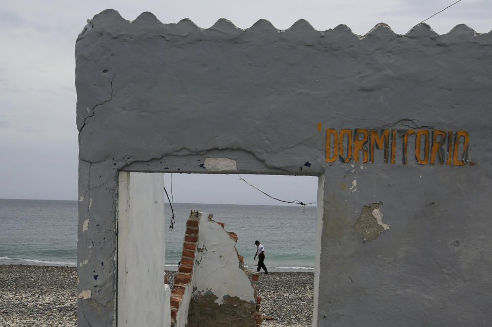 A prison guard walks on a beach past a dilapidated structure with the Spanish sign: Bedroom," during a media tour of the now closed Islas Marias penal colony located off Mexico's Pacific coast, Saturday, March 16, 2019. When Hurricane Willa made a direct hit as a Category 3 storm, it caused about $100 million in damages to the prison. (AP Photo/Rebecca Blackwell)