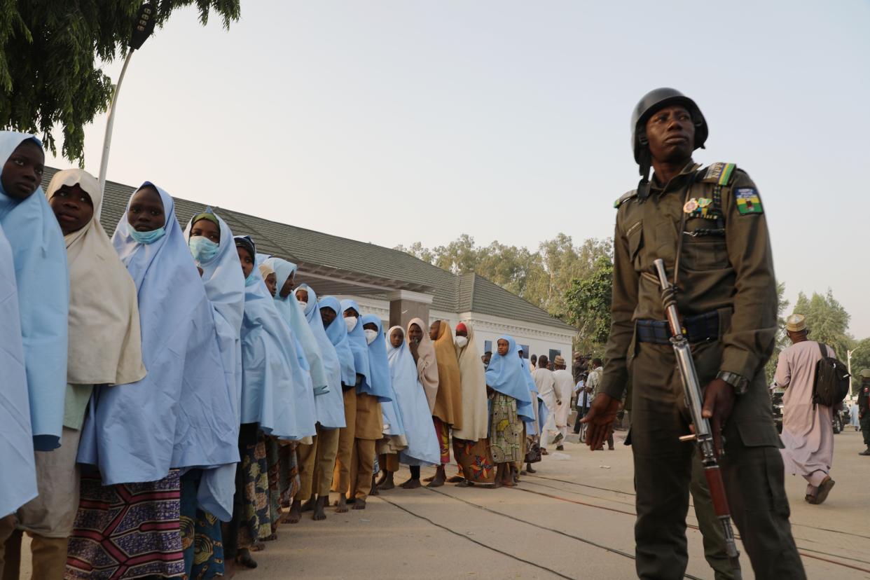 <p>A soldiers stands next to a group of girls previously kidnapped from their boarding school in Zamfara state </p> (AFP via Getty Images)