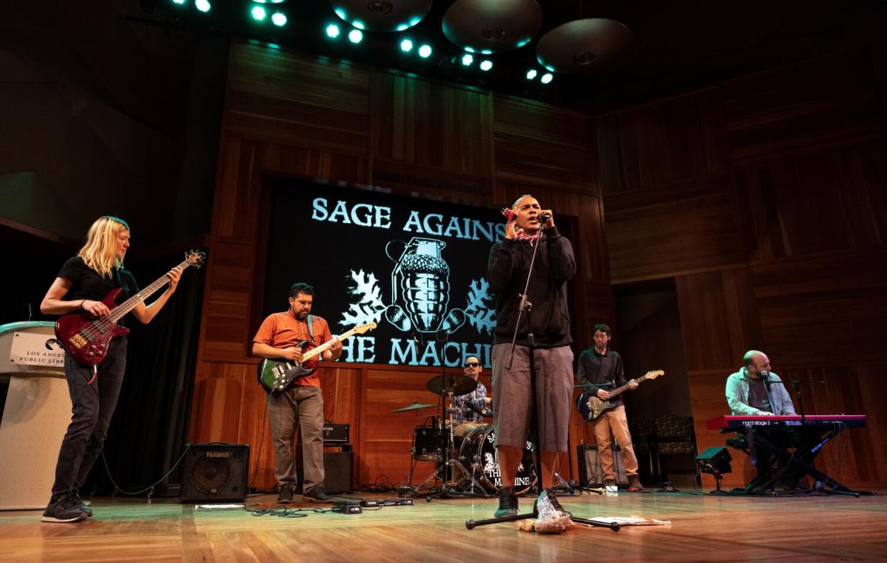 Six punk rock musicians onstage with frontman Antonio Sanchez singing in front, and his bandmates behind him.