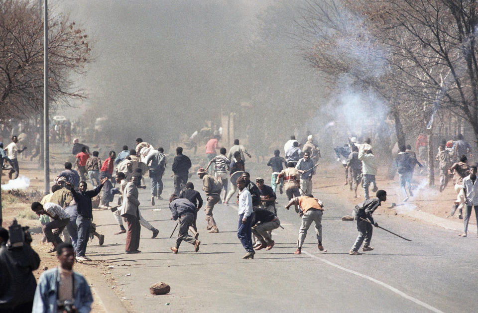 FILE — In this Aug. 17, 1990 file photo taken by South African photographer John Parkin, protestors are dispersed by teargas fired by police. Parkin, who covered the country's anti-apartheid struggle, its first democratic elections, and the presidency of Nelson Mandela, has died Monday Aug. 23, 2021, has died at the age of 63. (AP Photo/John Parkin/File)