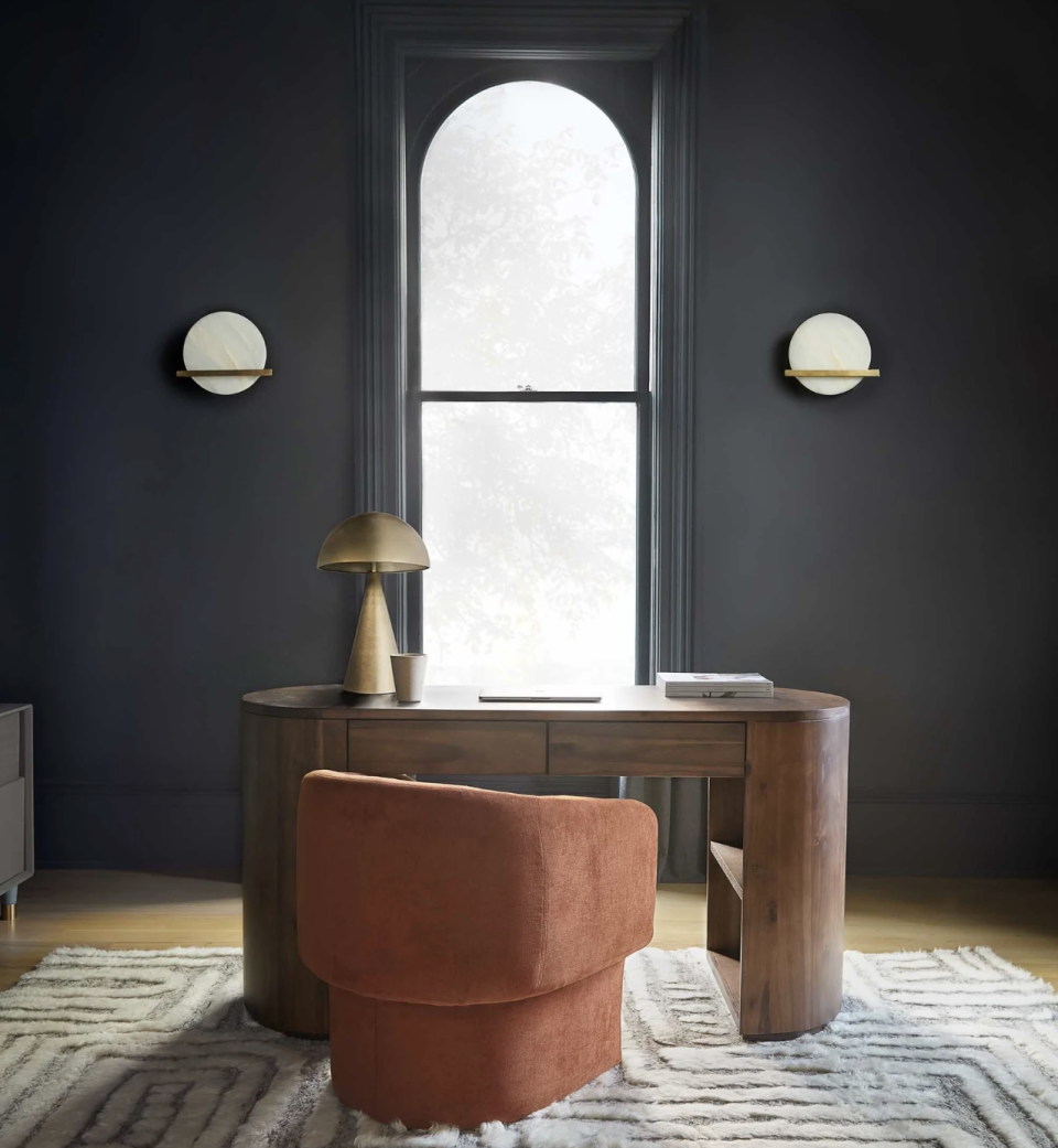 desk with curved edges and drawers in a dark blue home office