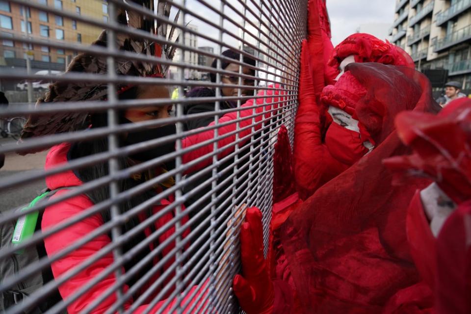 Members of the Red Rebel Brigade outside the Scottish Events Campus speak to delegates inside through the fencing on the perimeter (Andrew Milligan/PA) (PA Wire)