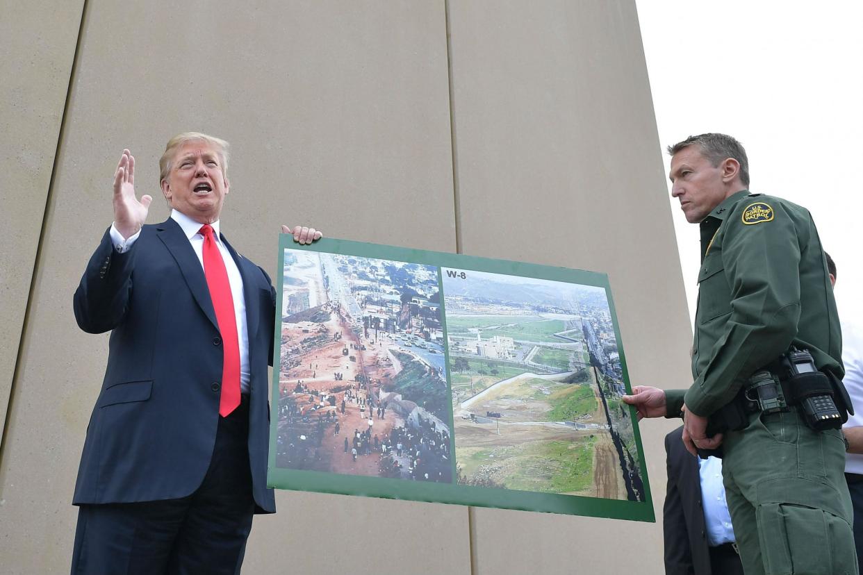 Mr Trump and Mr Scott with images of the border wall prototypes: Getty
