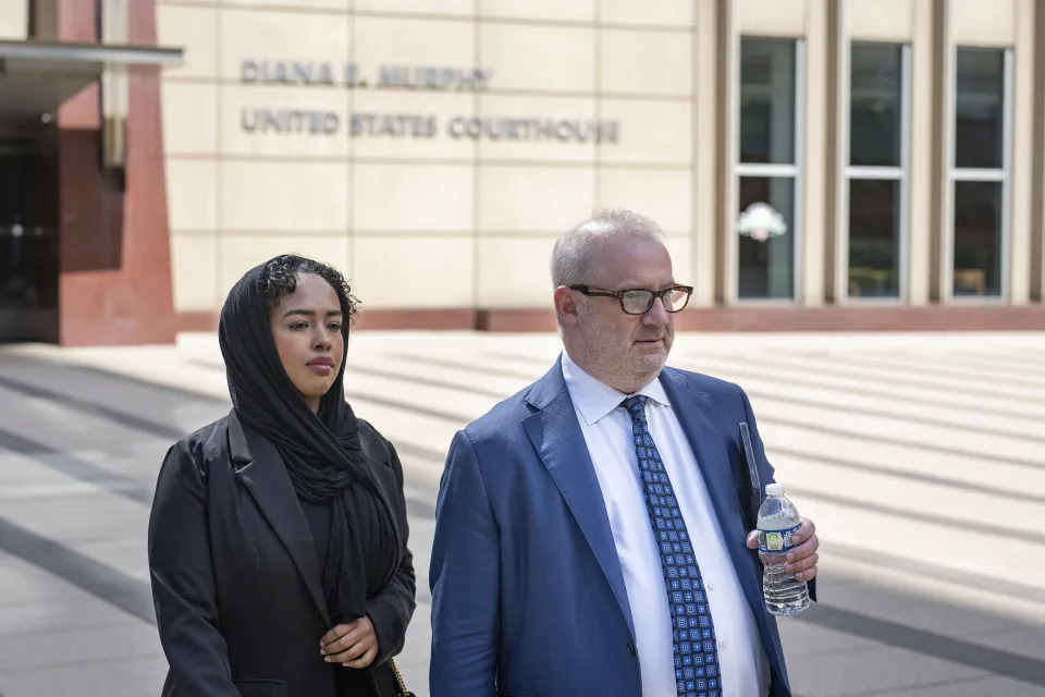 Ladan Mohamed Ali, left, a Seattle woman who attempted to bribe a Minnesota juror with a bag of $120,000 in cash in exchange for an acquittal in one of the country's largest COVID-19-related fraud cases, and her attorney, Eric Newmark, leave the Diana E. Murphy U.S. Courthouse, Thursday, Sept. 5, 2024, in Minneapolis, following after a hearing where she plead guilty. (Alex Kormann/Star Tribune via AP)