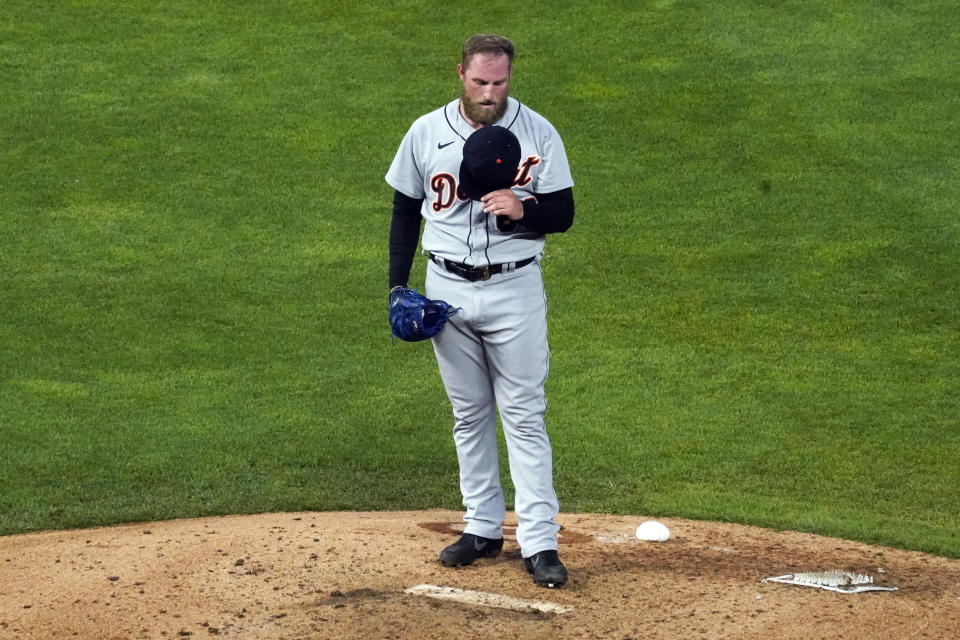 Detroit Tigers pitcher Ian Kool holds is cap to his chest after giving up a walk to Minnesota Twins' Alex Kirilloff in the sixth inning of a baseball game, Friday, July 9, 2021, in Minneapolis. (AP Photo/Jim Mone)