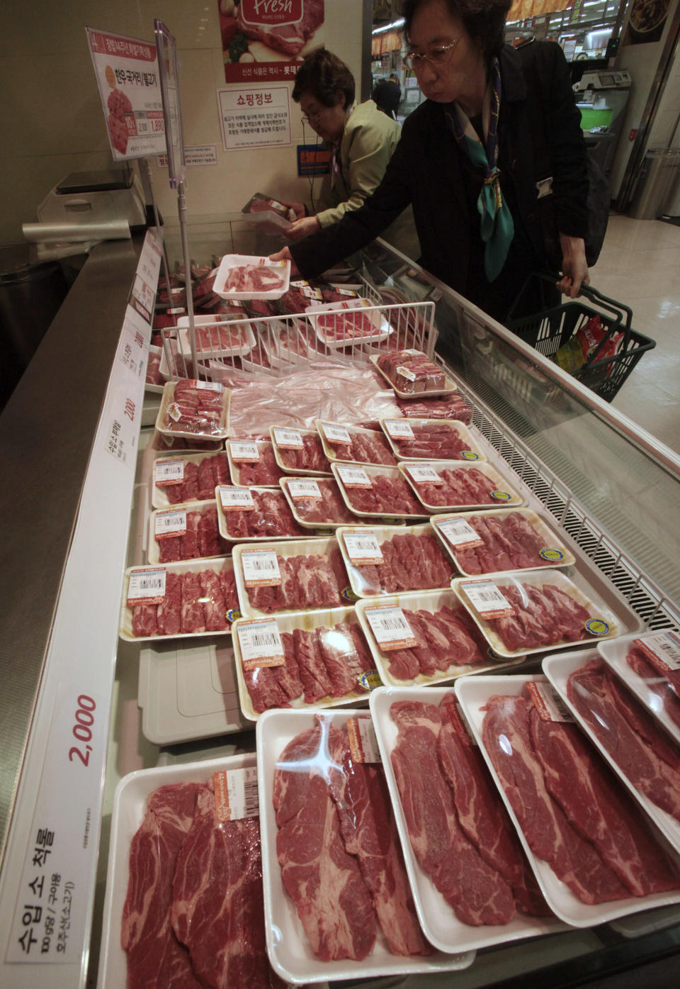 South Korean women watch to buy domestic beef as Australian beef is displayed, bottom, on the shelves at a Lotte Mart store in Seoul, South Korea, Wednesday, April 25, 2012. Two major South Korean retailers including Lotte Mart, suspended sales of U.S. beef Wednesday following the discovery of mad cow disease in a U.S. dairy cow. Reaction elsewhere in Asia was muted with Japan saying there's no reason to restrict imports. (AP Photo/Ahn Young-joon)