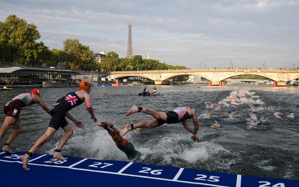 Swimmers dive into the Seine from a competition board