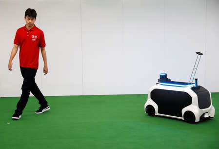 An employee of Toyota Motor Corp. demonstrates FRS field event support robot which will be used to support the Tokyo 2020 Olympic and Paralympic Games, during a press preview in Tokyo