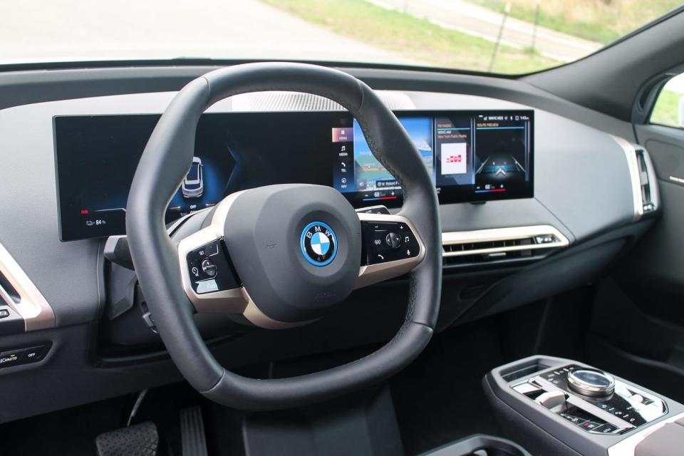 The 2022 BMW iX xDrive50's angular steering wheel, with its display behind.