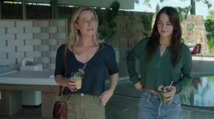 Heather and Zoe stnad outside holding colorful drinks decorated with flowers