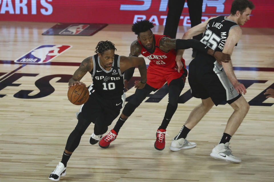 San Antonio Spurs forward DeMar DeRozan (10) drives past Houston Rockets forward Robert Covington (33) off a screen by center Jakob Poeltl (25) during the second half of a NBA basketball game Tuesday, Aug. 11, 2020, in Lake Buena Vista, Fla. (Kim Klement/Pool Photo via AP)