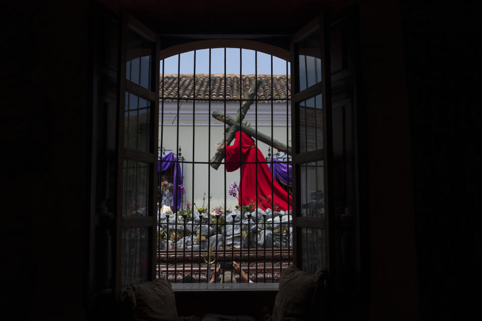 Penitents knows as cucuruchos carry a religious float transporting a 300-year-old, life-sized statue of Jesus Christ bearing the cross, during a Holy Week procession in Antigua, Guatemala, Good Friday, March 29, 2024. (AP Photo/Moises Castillo)