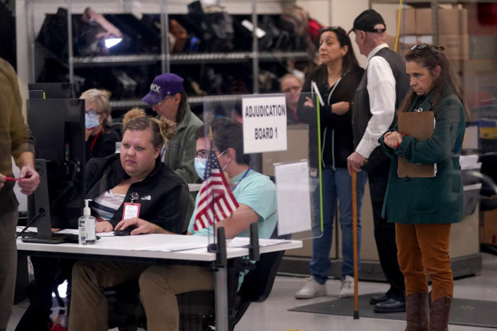 Election adjudicators and observers watch ballot tabulation inside the Maricopa County Recorders Office, Thursday, Nov. 10, 2022, in Phoenix. (AP Photo/Matt York)