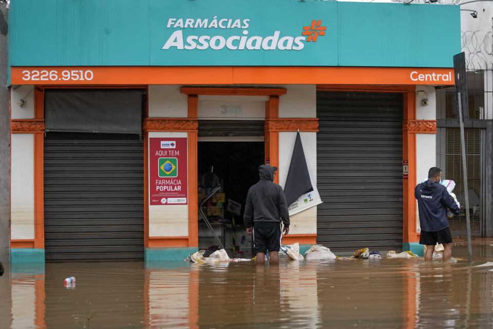 Drugstore employees recover items after a flood due to heavy rains, in Porto Alegre, Rio Grande do Sul state, Brazil, Saturday, May 11, 2024. (AP Photo/Andre Penner)