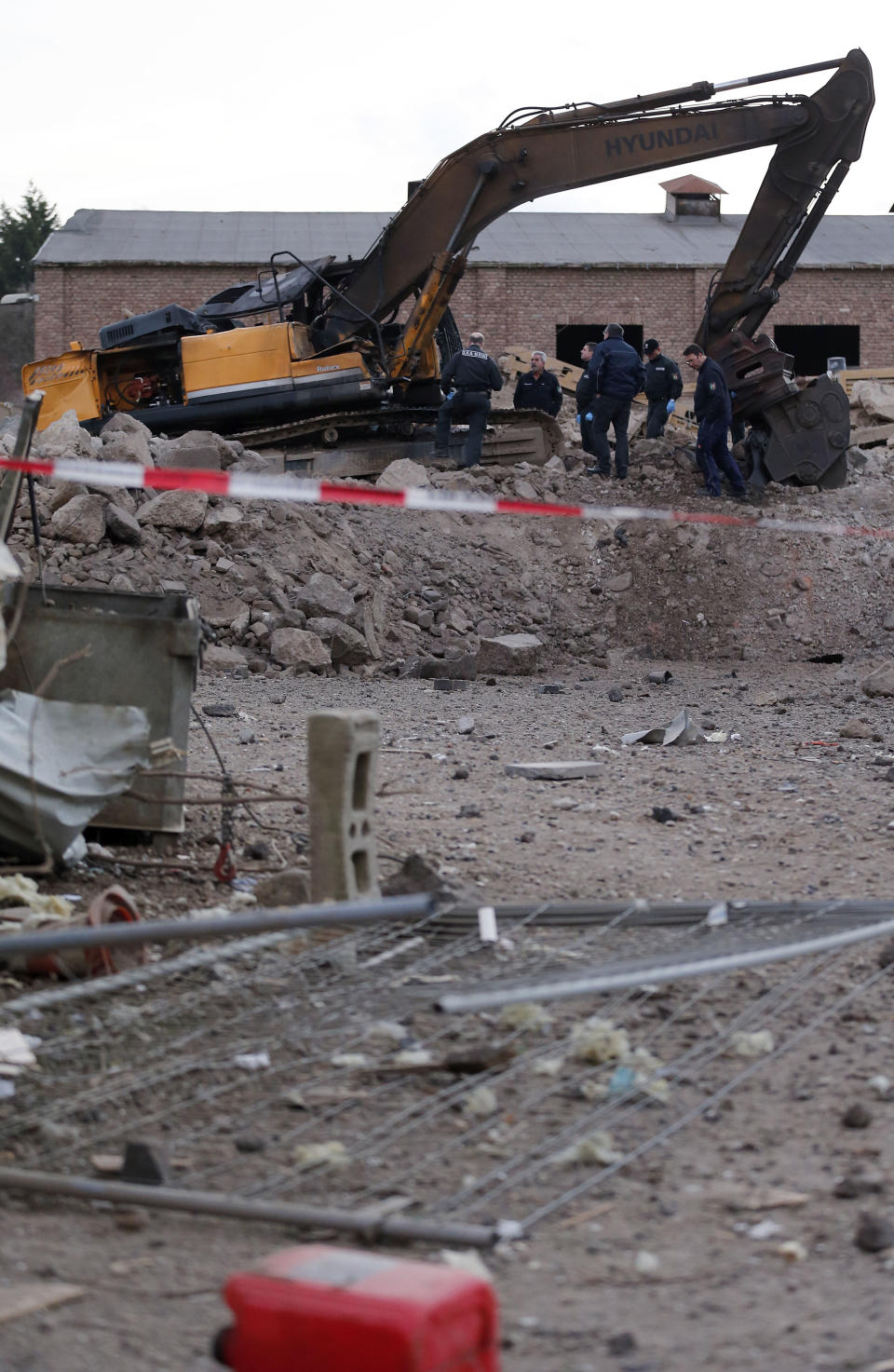 Police forces examine the scene of a World War II bomb explosion during construction works of a digger in Euskirchen, Germany, Friday, Jan. 3, 2014. Police say one person was killed and several others were injured. (AP Photo/Frank Augstein)