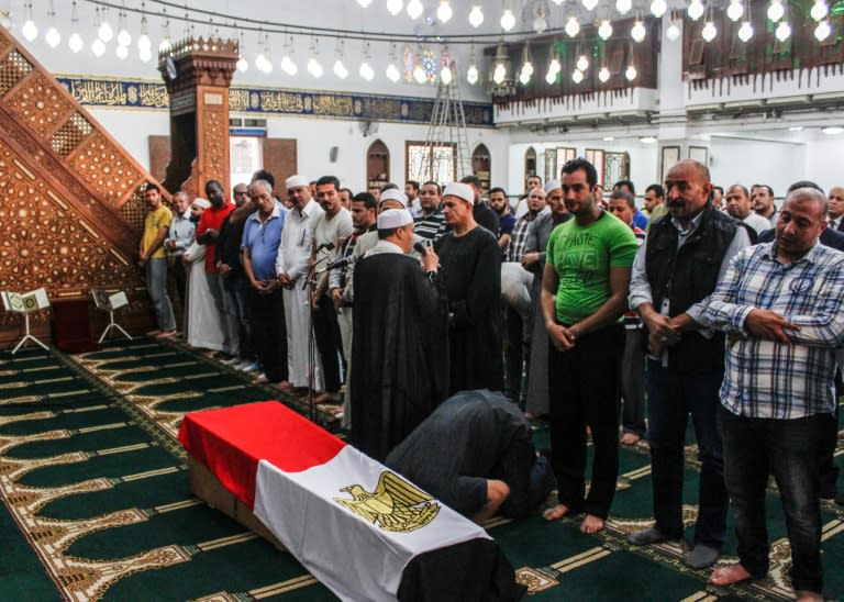 Egyptians pray before the coffin of a policeman killed in clashes with militants on the road to the Bahariya oasis, at a funeral in Cairo on October 21