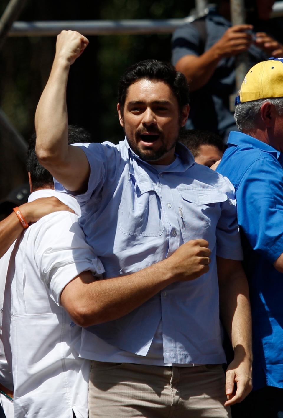 Carlos Vecchio, national political coordinator of the Popular Will party, an anti-government group formed by jailed opposition leader Leopoldo Lopez before his arrest, greets supporters upon his arrival at an anti-government protest in Caracas, Venezuela, Saturday, March 22, 2014. Vecchio addressed the crowd in defiance of an arrest order. (AP Photo/Fernando Llano)