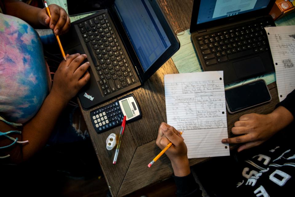 Curiah Simpson, 18, and Destiny Taylor, 12, work on their school work at the dining room table in their home in North College Hill on Thursday, April 2, 2020. The sisters expressed how much they missed being in a classroom and having teachers to help them with their work. 