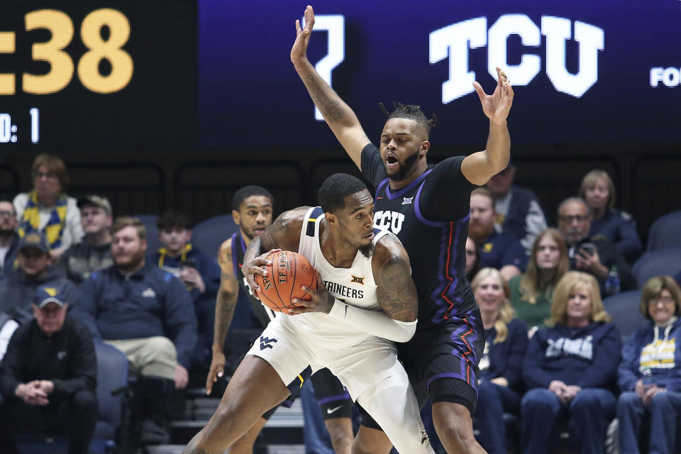 West Virginia forward Jimmy Bell Jr. is defended by TCU center Eddie Lampkin Jr. (4) during the first half of an NCAA college basketball game Wednesday, Jan. 18, 2023, in Morgantown, W.Va. (AP Photo/Kathleen Batten)