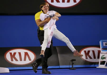 A protester is removed from the court by a security personnel during the men's singles final match between Novak Djokovic of Serbia and Andy Murray of Britain at the Australian Open 2015 tennis tournament in Melbourne February 1, 2015. REUTERS/Issei Kato