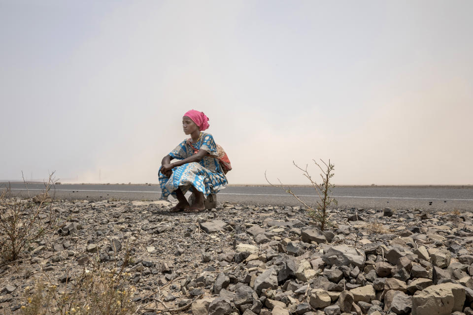 In this July 12, 2019 photo, 18-year-old Raheema Sanu, an Ethiopian migrant, rests on the side of a road, about 31 miles (50 kilometers) from Ali Sabeih, Djibouti. (AP Photo/Nariman El-Mofty)