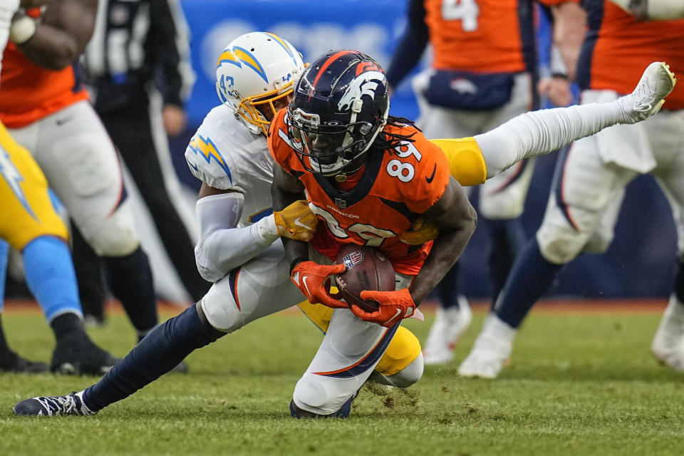 Los Angeles Chargers tight end Donald Parham Jr. (89) is tackled by Los Angeles Chargers cornerback Michael Davis (43) during the second half of an NFL football game, Sunday, Dec. 31, 2023, in Denver. (AP Photo/Jack Dempsey)