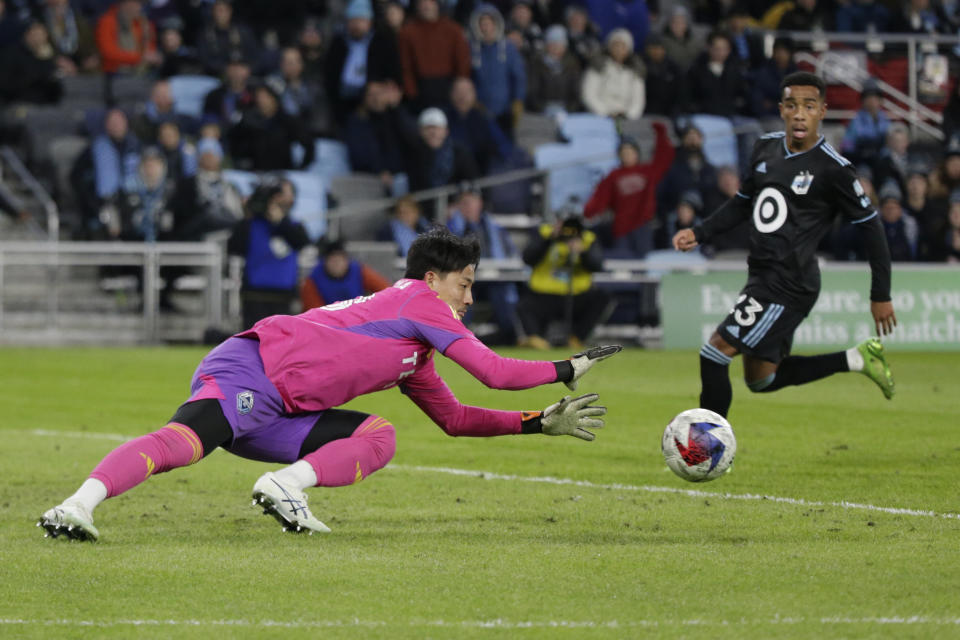 Vancouver Whitecaps goalkeeper Yohei Takaoka (18) makes a save as Minnesota United forward Cameron Dunbar (23) runs by in the second half of an MLS soccer game Saturday, March 25, 2023, in St. Paul, Minn. (AP Photo/Andy Clayton-King)