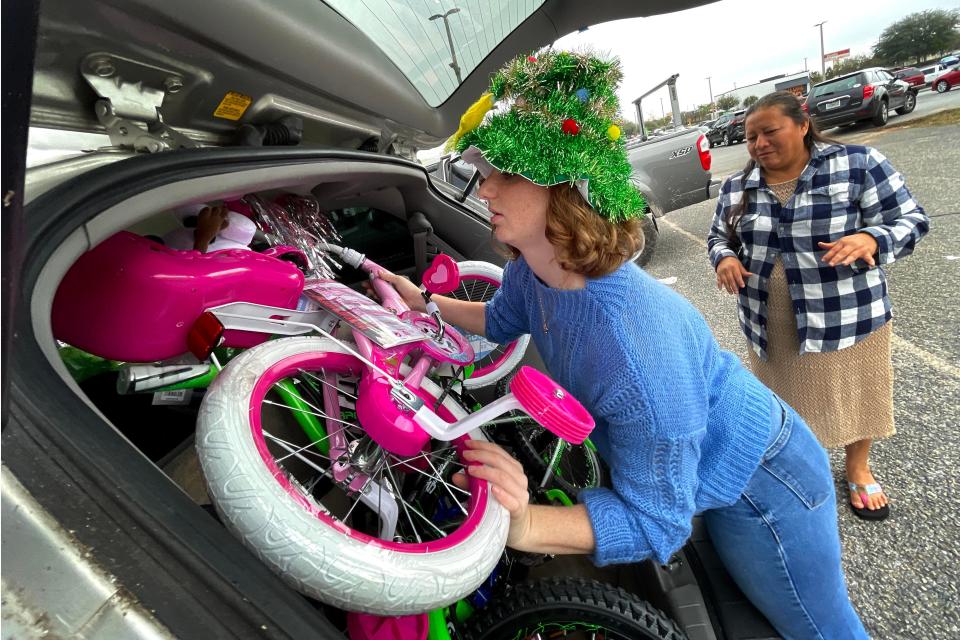 Volunteer Mary Brandt loads bicycles into a vehicle Thursday during the Salvation Army Angel Tree program distribution. Working with Catholic Charities, the Salvation Army Angel Tree program will help bring Christmas to more than 800 local children this year.